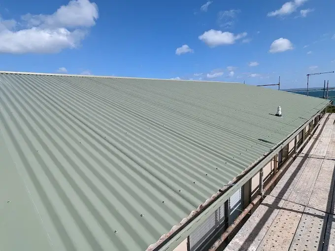 Large green metal roof repaired on a residential building in Melbourne.