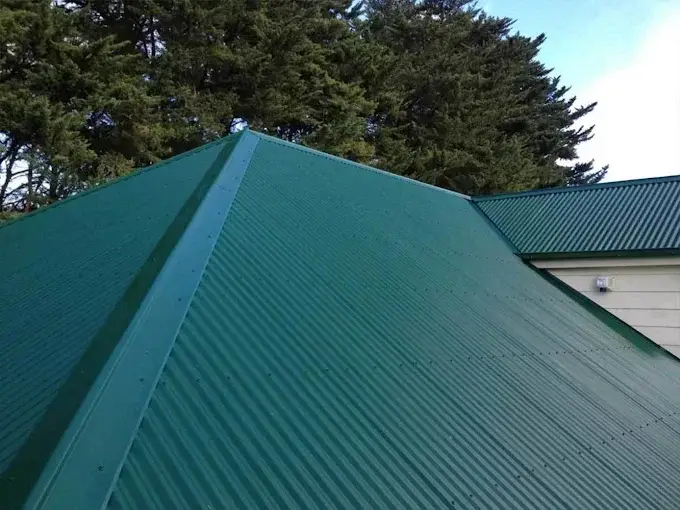 Close-up of a green metal roof after replacement on a residential property.