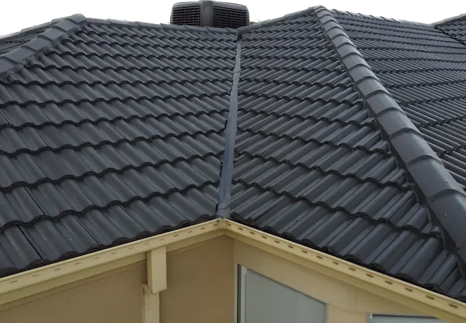 Close-up of a repaired tiled roof with clean ridge and valley lines.
