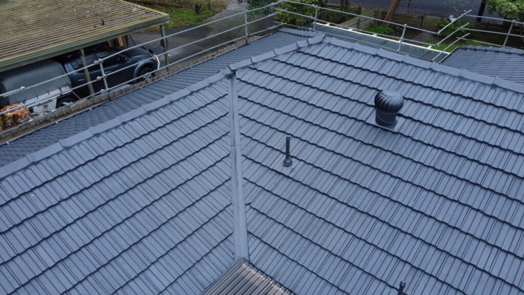 Close-up of tile roof restoration in Ringwood showing freshly painted tiles, ridge pointing, and vent pipes professionally resealed.