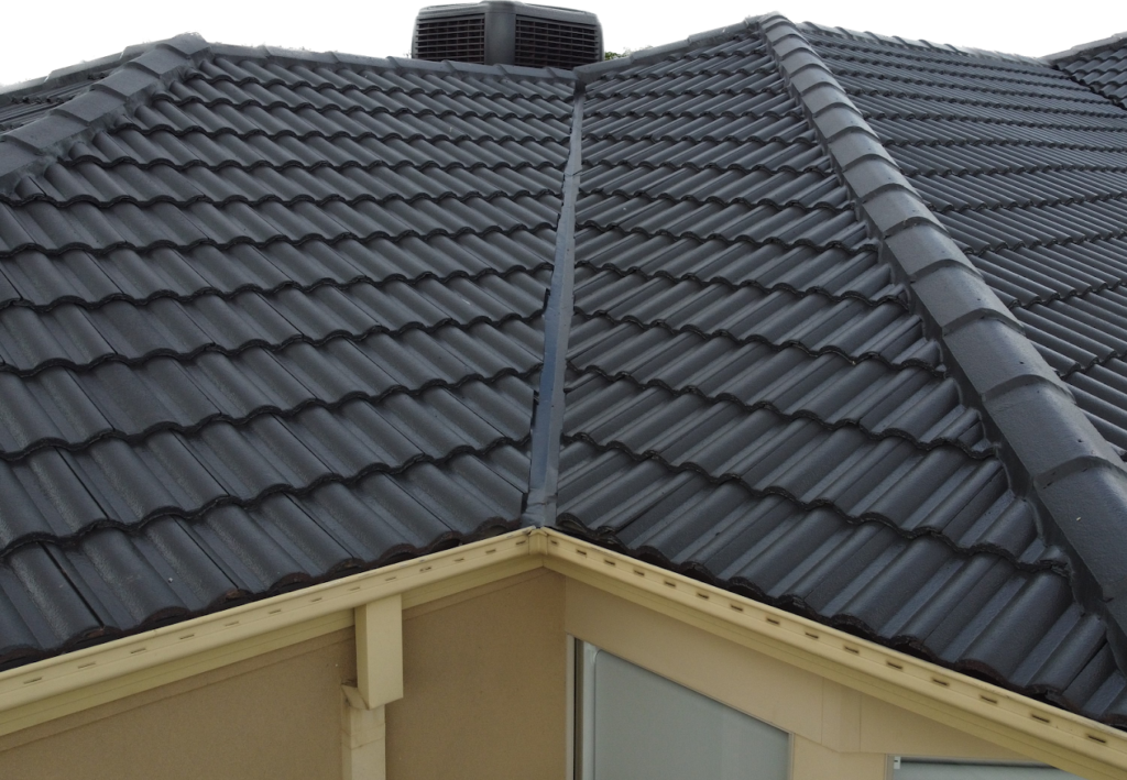 Roof restoration finished in Malvern, with moss removal, repaired ridge capping, and a fresh coat applied to match the original tile colour.