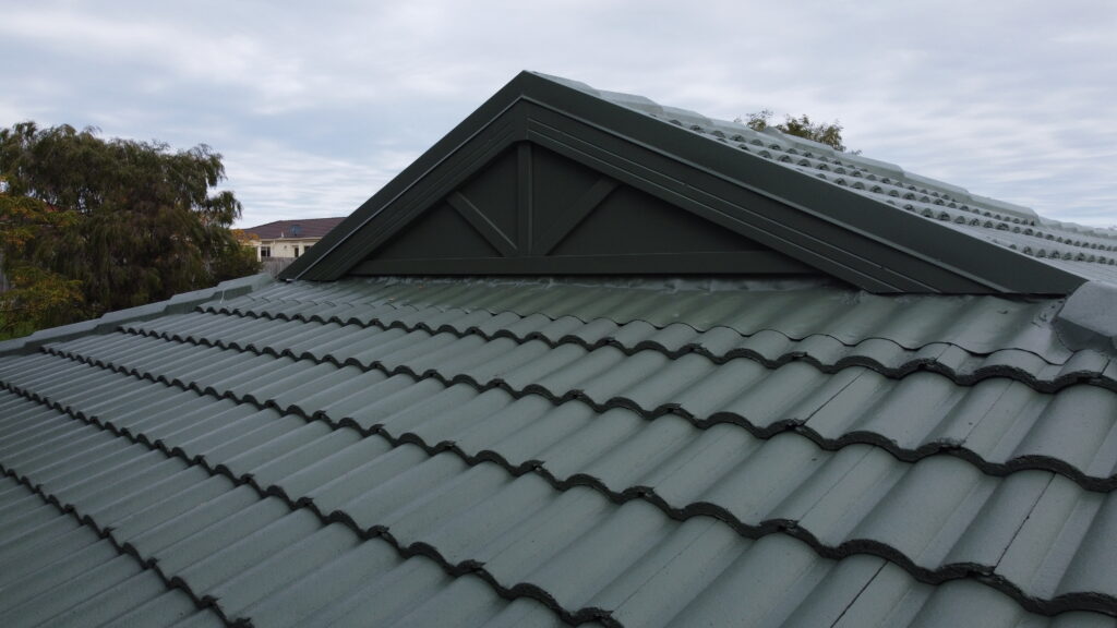 Close-up view of a freshly repaired tiled roof on a brick house in Berwick, showing neat tile alignment and clean finish.