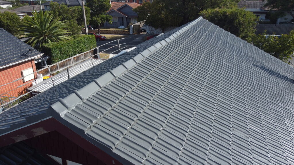 Side perspective of tile roof repair in Bentleigh on a federation-style home, highlighting resealed tiles and updated flashing near gables.
