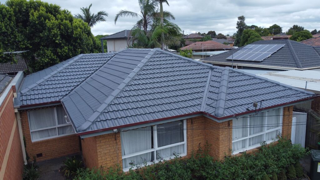 Aerial view, Melbourne home’s restored tiled roof, lush surrounds.