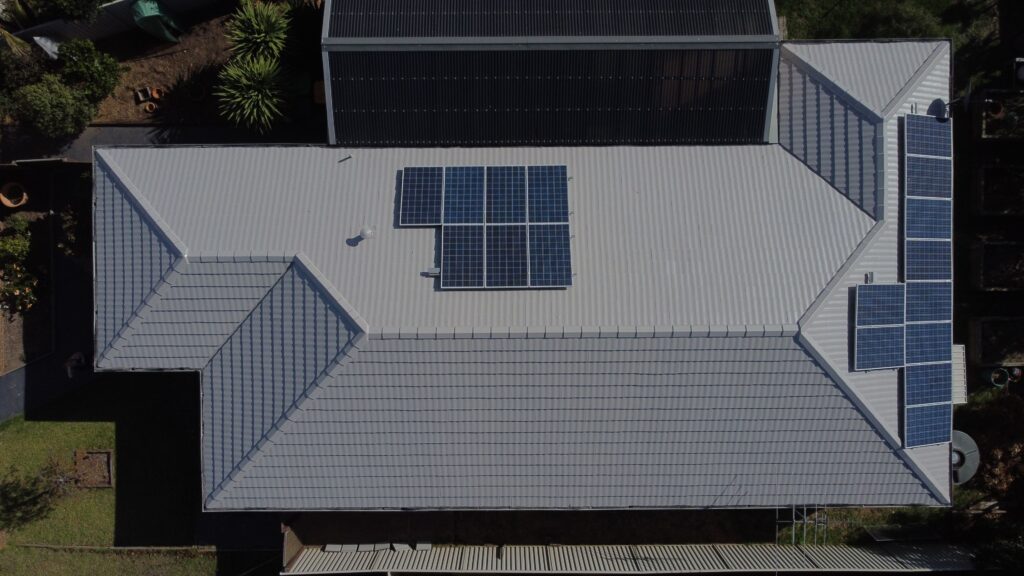 Melbourne home with gray metal roof, solar panels; roofing repair and restoration possible.