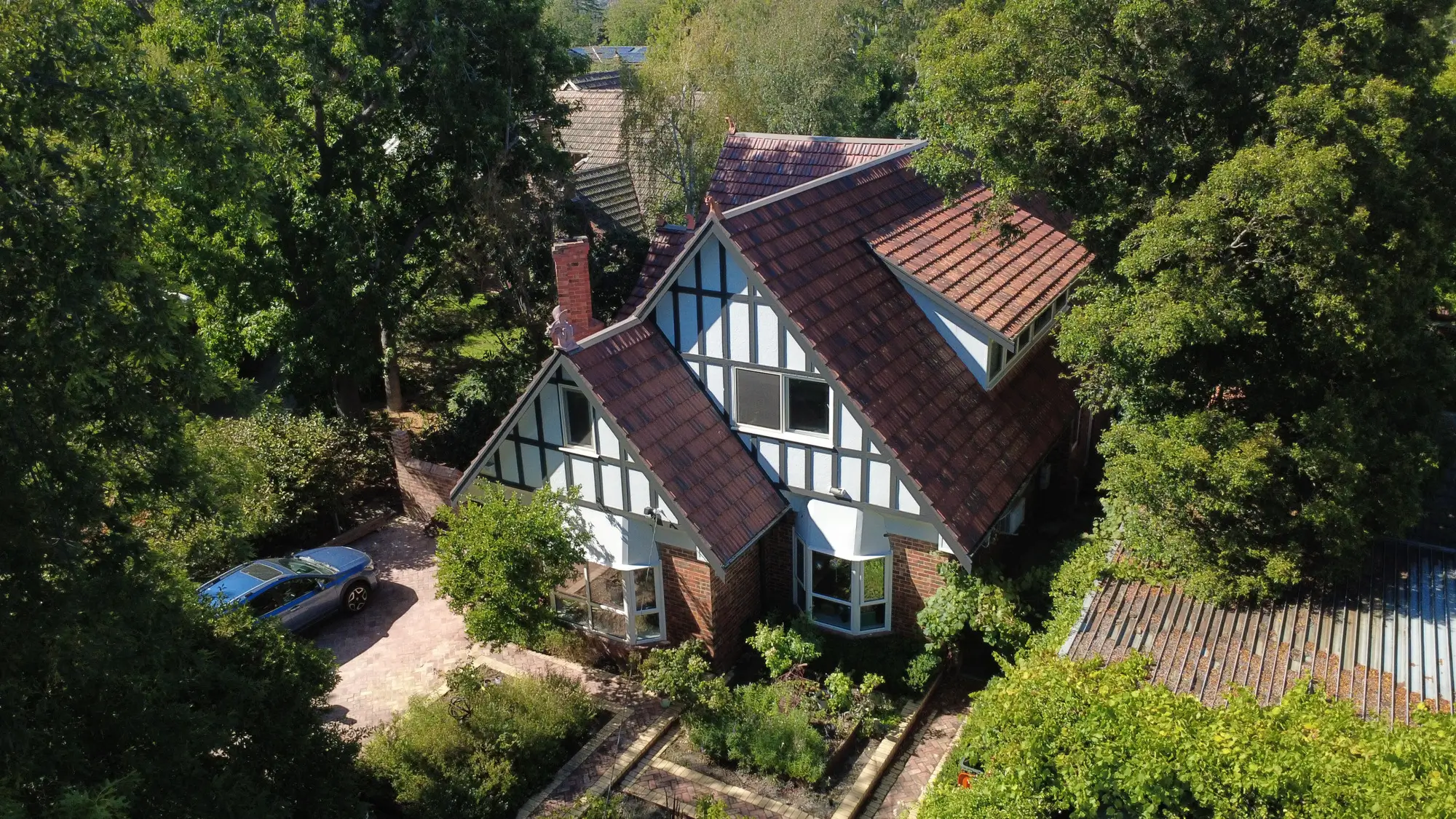 Aerial view, Tudor house, red roof repair in Melbourne.